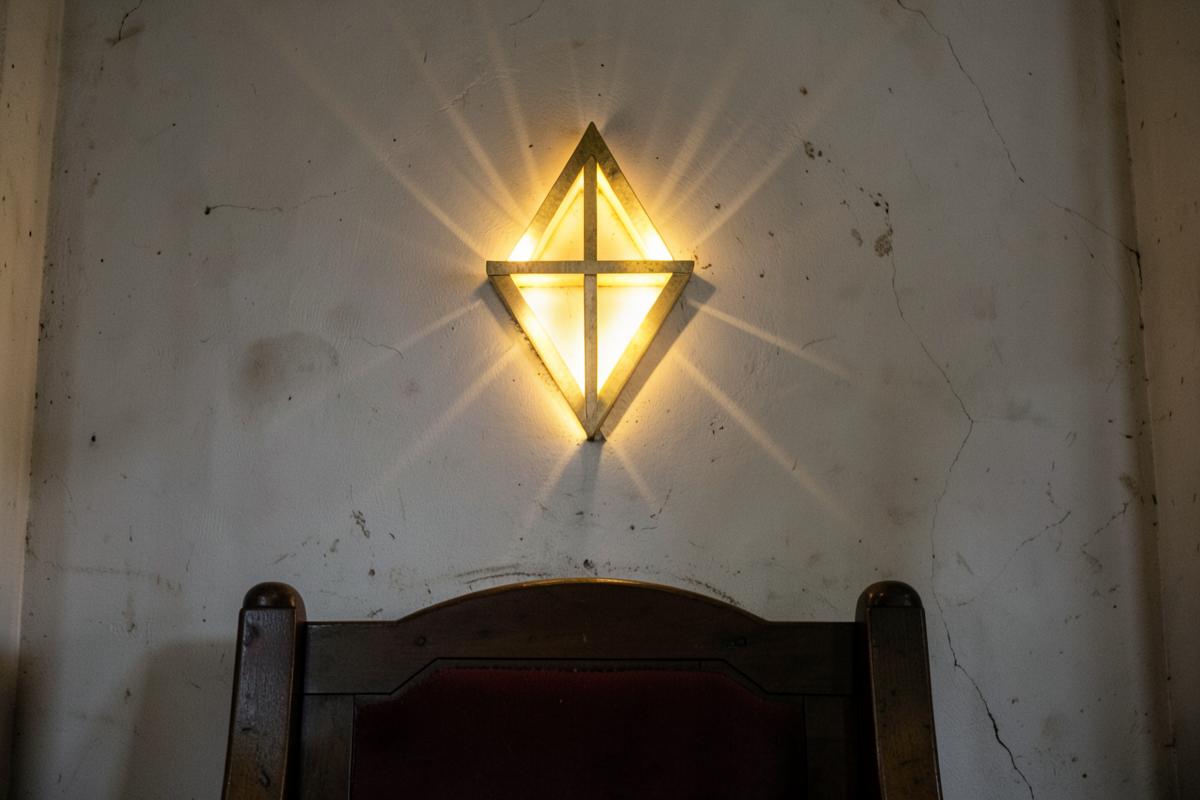 Compasso de metal e prancha de projeto sobre mesa de madeira, com um delta luminoso ao fundo