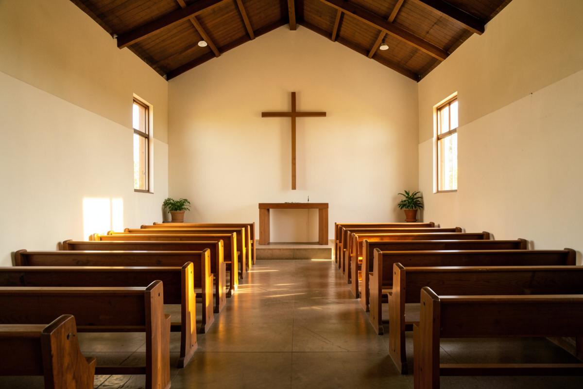 Interior simples de igreja evangélica com bancos de madeira e cruz