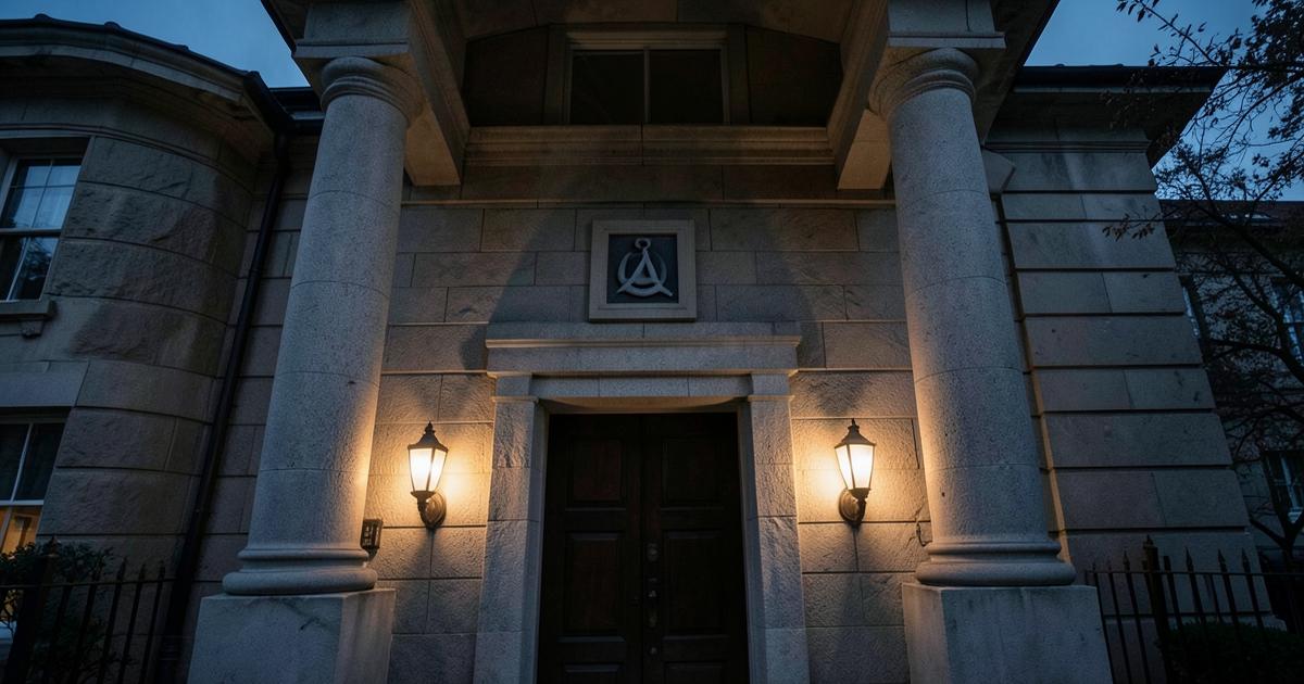 Fachada de um templo maçônico ao anoitecer, com colunas de pedra, lampiões acesos e emblema discreto acima da porta
