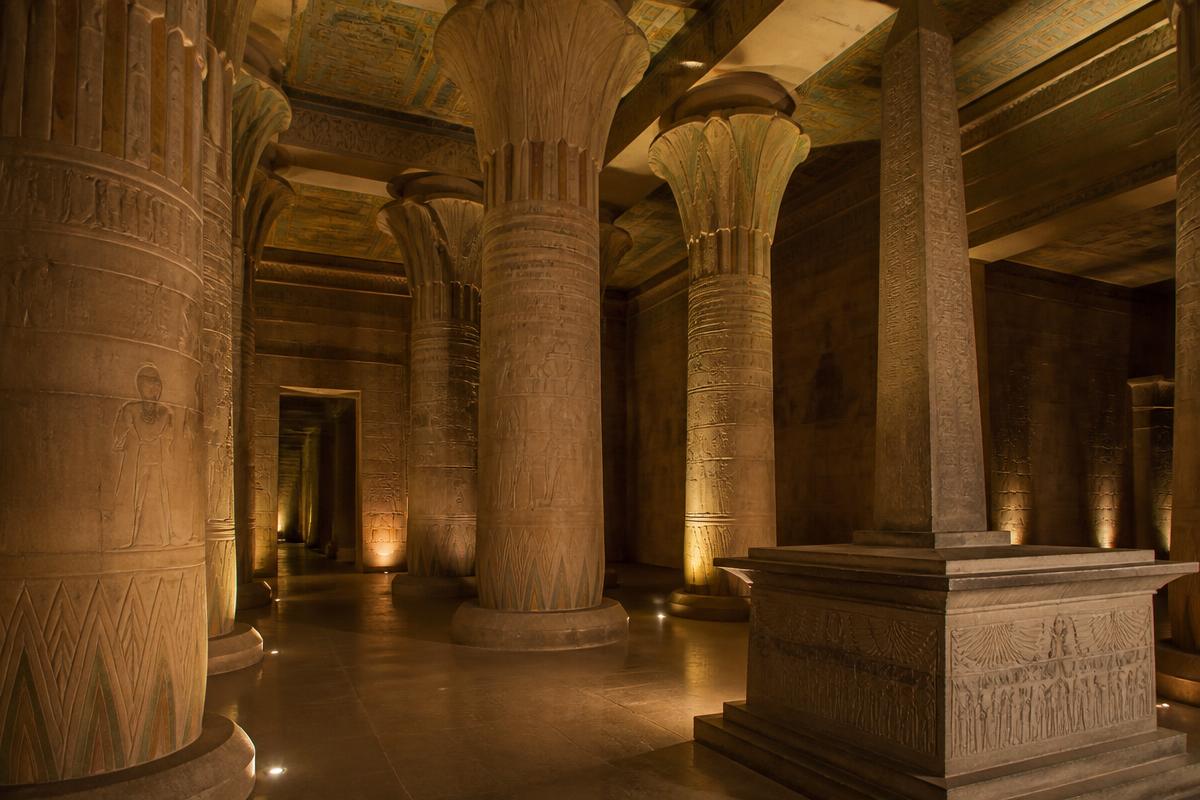Interior de templo de inspiração egípcia com colunas de lótus e obelisco